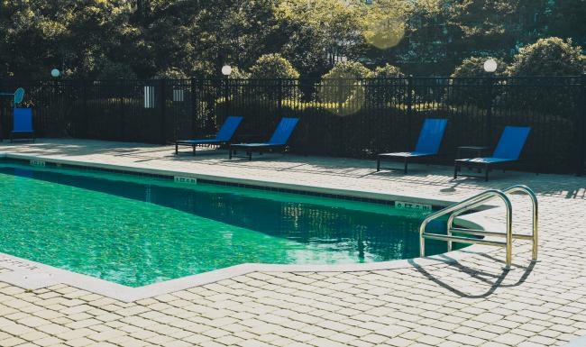a swimming pool with chairs around it