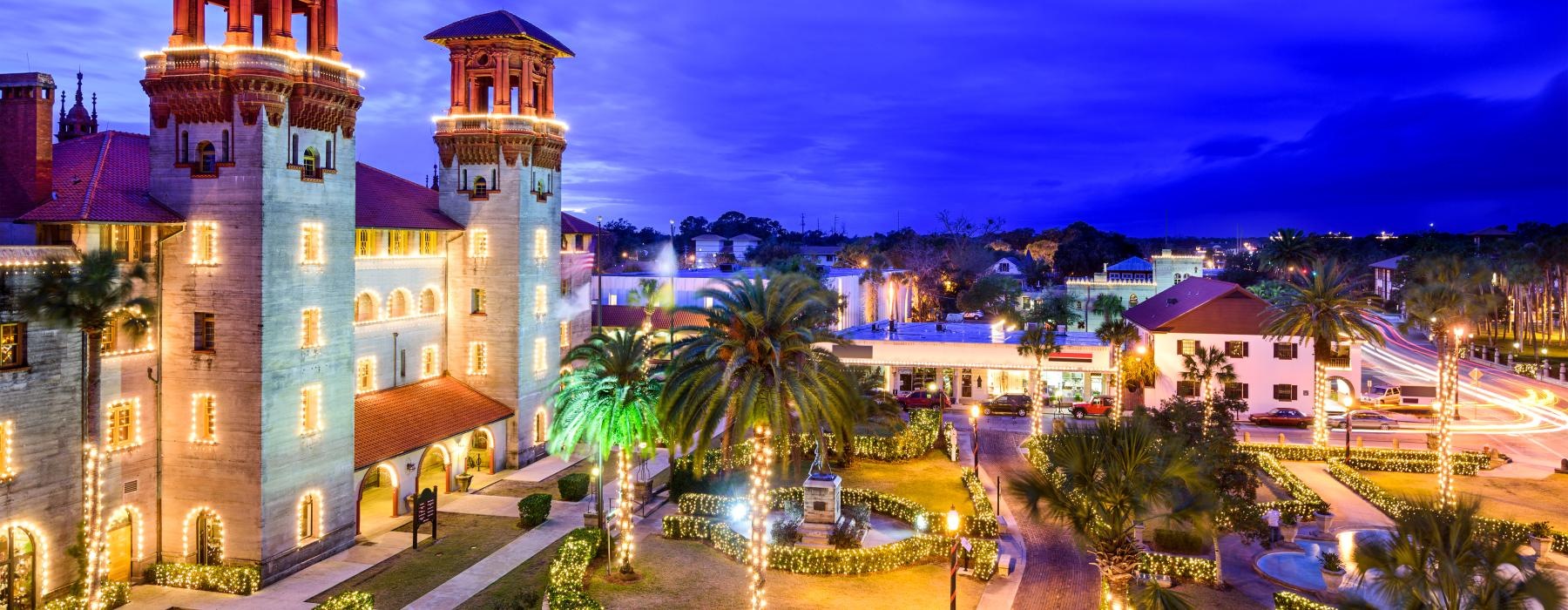 a building with a tower and palm trees in front of it